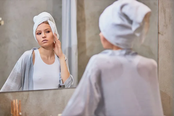 Wanita yang menarik melihat cermin di kamar mandi — Stok Foto