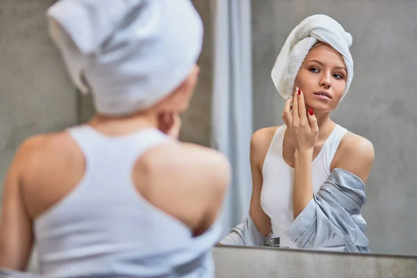young lady take care of skin on face after shower