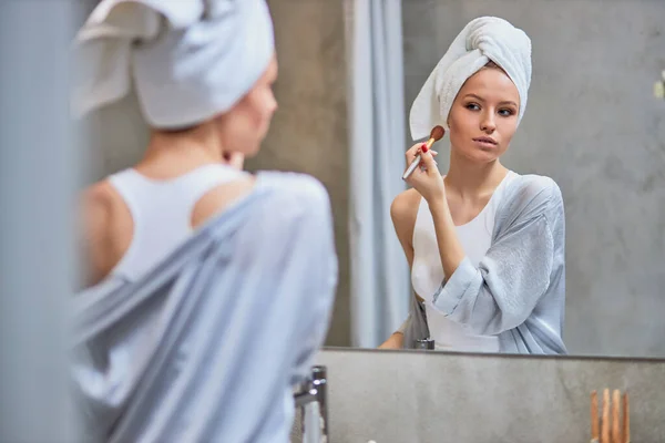 Wanita muda melakukan makeup di wajah setelah mandi — Stok Foto