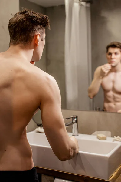 Beautiful muscular guy in bathroom at morning — Stockfoto