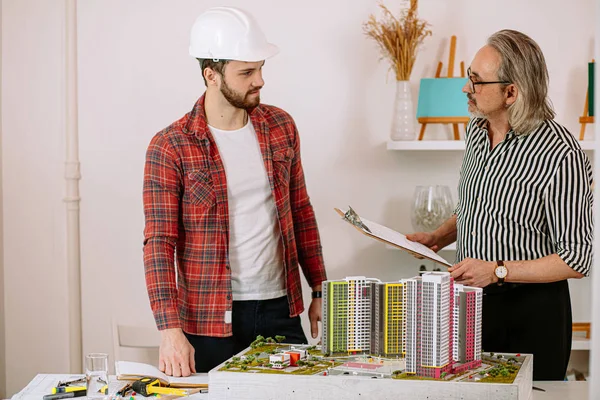 Professionele volwassen architect deelt ervaring met stagiair — Stockfoto