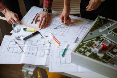 close-up man using blueprints in office