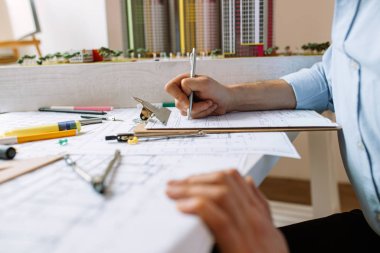close-up man using blueprints in office