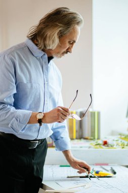gray-haired adult architect man working in office