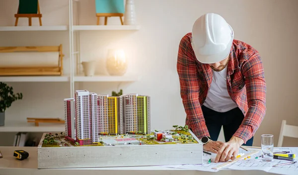 Jovem arquiteto trabalhando com plantas no escritório — Fotografia de Stock