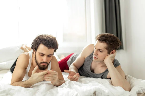 Gay los hombres tener conversación acostado en cama —  Fotos de Stock