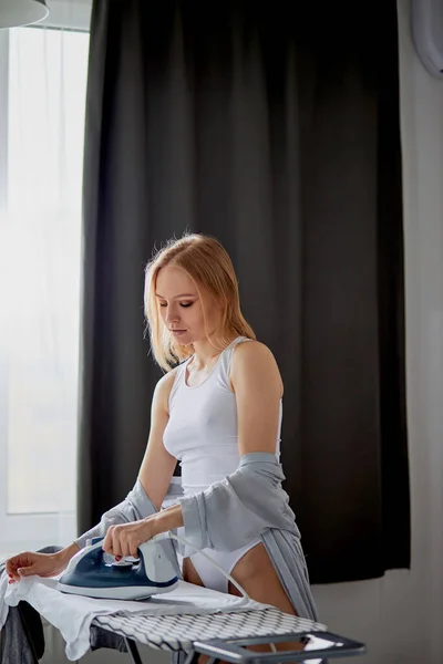 Young caucasian lady ironing home clothes — 스톡 사진