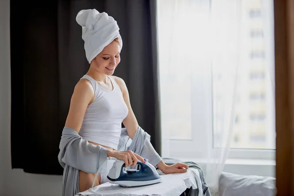 Attractive housewife iron clothes at home — Stock Photo, Image