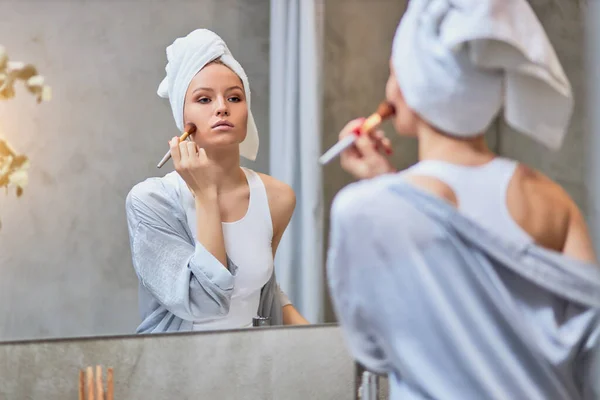 Wanita muda melakukan makeup di wajah setelah mandi — Stok Foto