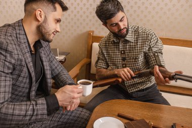 customer and salesman discuss rifle for hunting