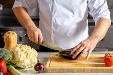 Aşçı mutfakta taze sebze kesiyor.