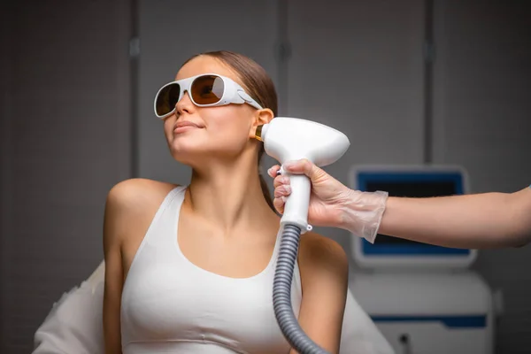 Mujer joven disfrutar de recibir tratamiento de depilación láser en la cara en el salón de belleza — Foto de Stock