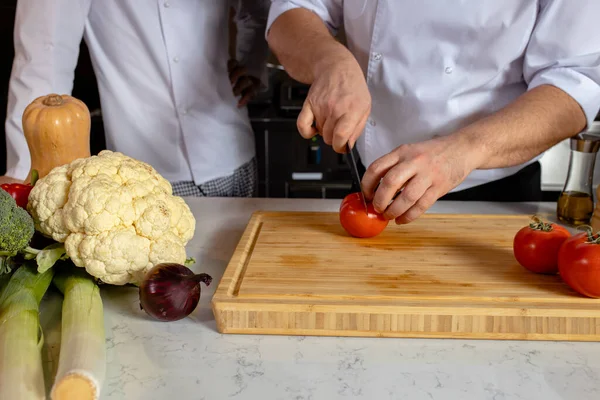 Chef-fogão cortar legumes frescos na cozinha — Fotografia de Stock