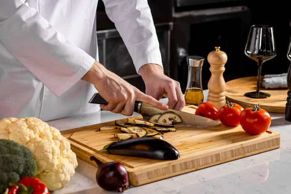 Foto de cerca del chef-cocinero recortando verduras en la cocina —  Fotos de Stock