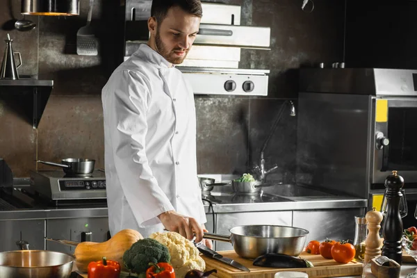 Guapo joven cocinero en el proceso de cocción —  Fotos de Stock