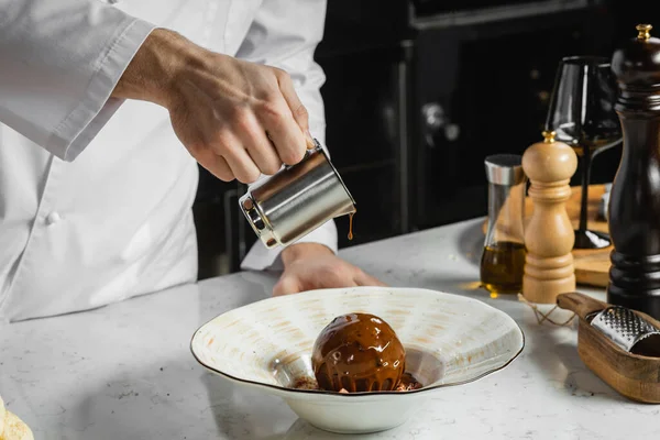 Cocinero recortado verter chocolate caliente en postre dulce —  Fotos de Stock