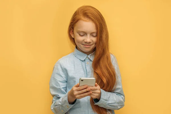 Positief Kaukasisch rood harig meisje met mobiele telefoon — Stockfoto