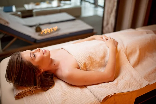 Atractiva mujer caucásica acostada en la cama después de un masaje recreativo —  Fotos de Stock