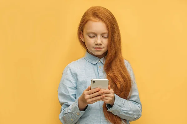 Schattig Kaukasisch rood harig meisje met mobiele telefoon — Stockfoto