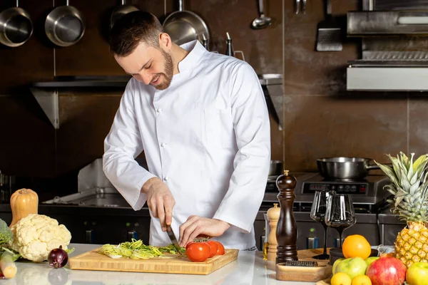 Jovem chef-fogão corte de legumes frescos — Fotografia de Stock