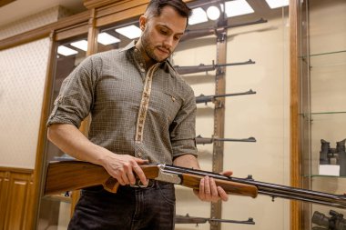 caucasian guy came to get new rifle for hunting
