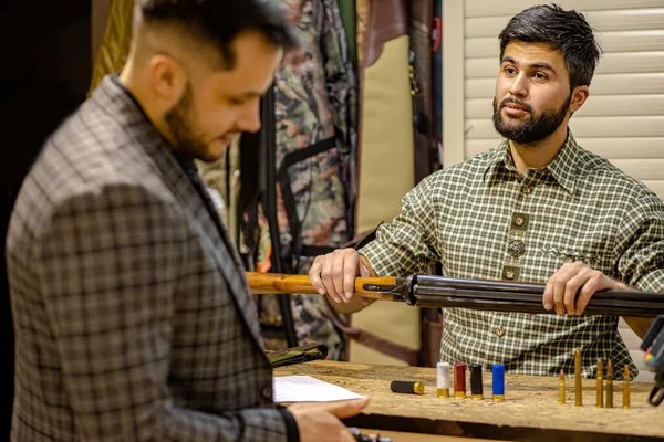 Vendedor afable ofrecen armas de fuego al cliente — Foto de Stock