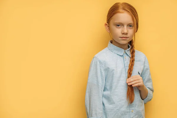 빨간 머리의 심각 한 소녀의 사진 이 노란 배경에 고립되어 있습니다 — 스톡 사진
