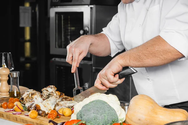 Cocinero profesional cortar la carne cocida para los visitantes del restaurante —  Fotos de Stock