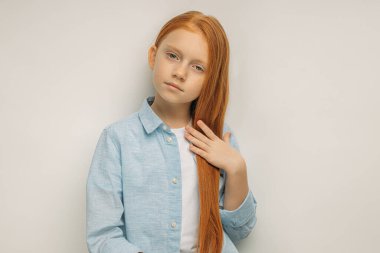 Uzun kızıl saçlı sevimli bir kız çocuğu.