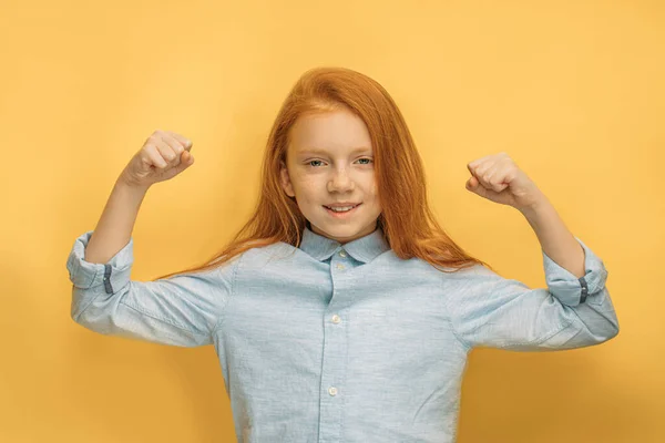 Sterk kind meisje tonen spieren op armen, geïsoleerd — Stockfoto