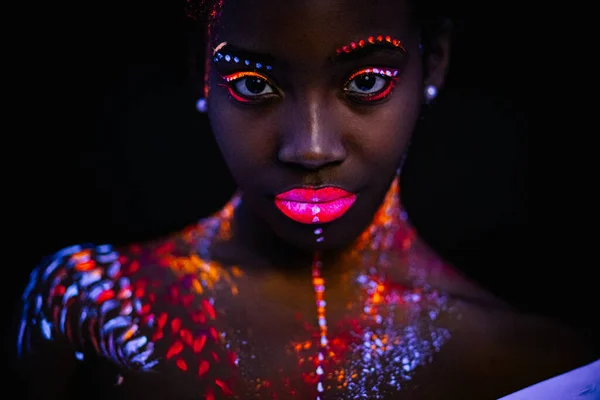 beautiful girl with creative fluorescent prints on skin