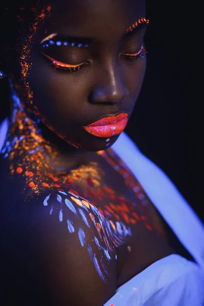 Afrikansk modell i neonljus, flicka med fluorescerande makeup — Stockfoto