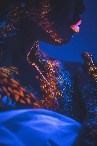 Πλαϊνή όψη σε νεαρή Αφρικανή γυναίκα με φθορίζοντα αποτυπώματα στο πρόσωπο — Φωτογραφία Αρχείου