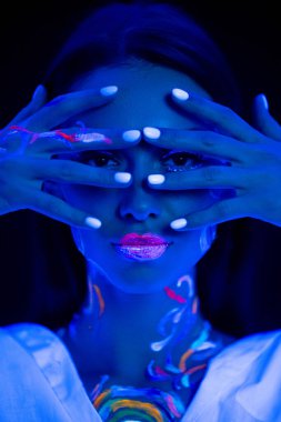 Cildinde floresan izleri olan bir kadın gözleri kapalı elleriyle