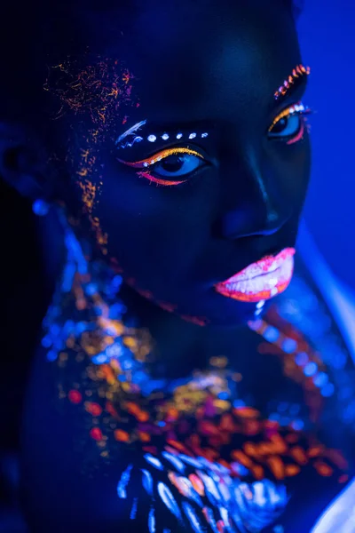 Ovanlig fotografering av kvinna med fluorescerande make-up i ansiktet — Stockfoto