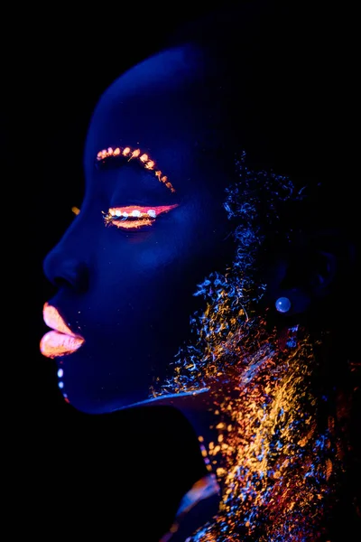 Africký model v neonovém světle, dívka s fluorescenčním líčidlem — Stock fotografie