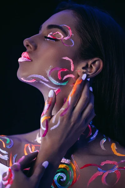 Vista lateral de la hermosa mujer joven con impresiones fluorescentes en la piel — Foto de Stock