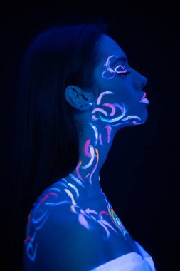 Cildinde floresan izleri olan güzel genç bir kadının yan görüntüsü.