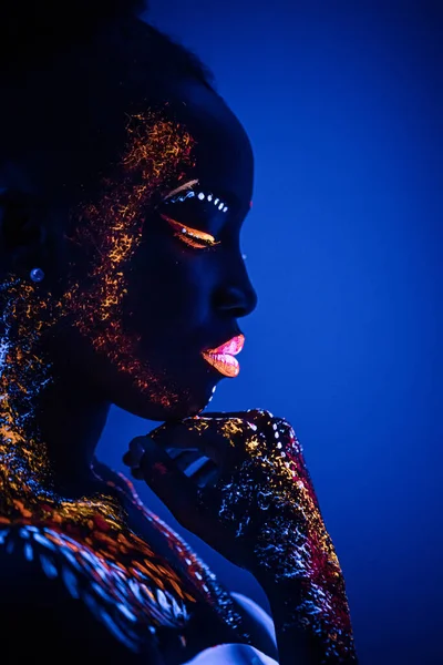 Modelo africano en luz de neón, chica con maquillaje fluorescente —  Fotos de Stock