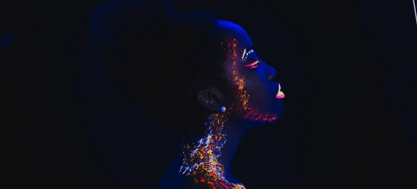 Boční pohled na mladou africkou ženu s fluorescenčními potisky na obličeji — Stock fotografie