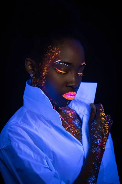 african model in neon light, girl with fluorescent makeup