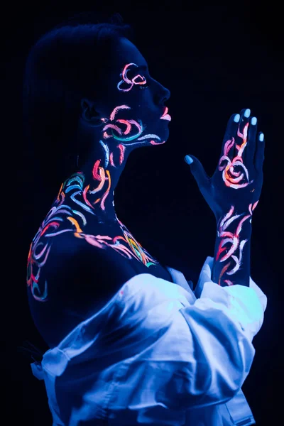 Seitenansicht einer Frau mit flioreszierenden Abdrücken auf der Haut, bete — Stockfoto