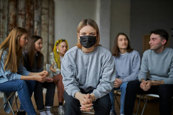 Молодые женщины сидят в маске изолированы от общества — стоковое фото