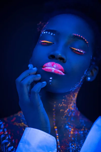 portrait of young beautiful model girl with fluorescent makeup isolated