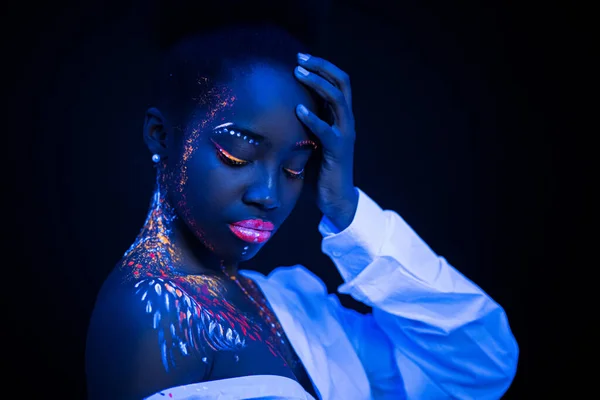 Modelo africano en luz de neón, chica con maquillaje fluorescente —  Fotos de Stock