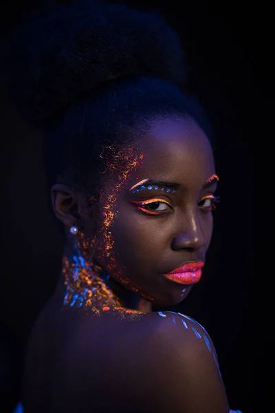 Fluorescencyjny makijaż na skórze kobiecej świecącej w świetle ultrafioletowym — Zdjęcie stockowe