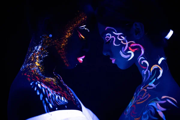 Девушки с флуоресцентным макияжем напротив друг друга — стоковое фото
