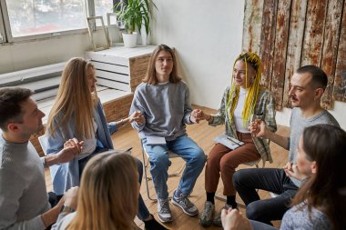 Kulüp üyeleri çemberde el ele tutuşuyorlar.