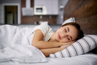 Sevimli kadın yatakta uyumaktan hoşlanıyor.