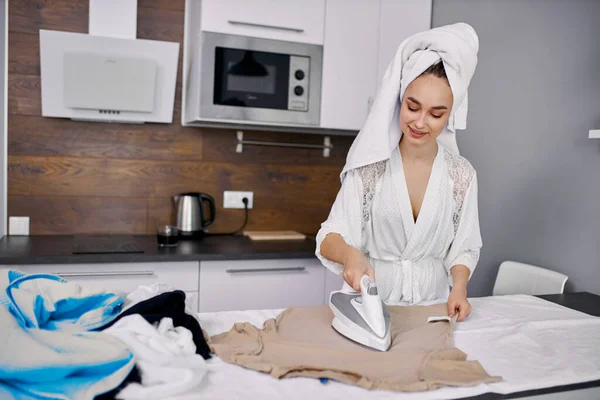 Wanita cantik menikmati menyetrika pakaian di rumah — Stok Foto